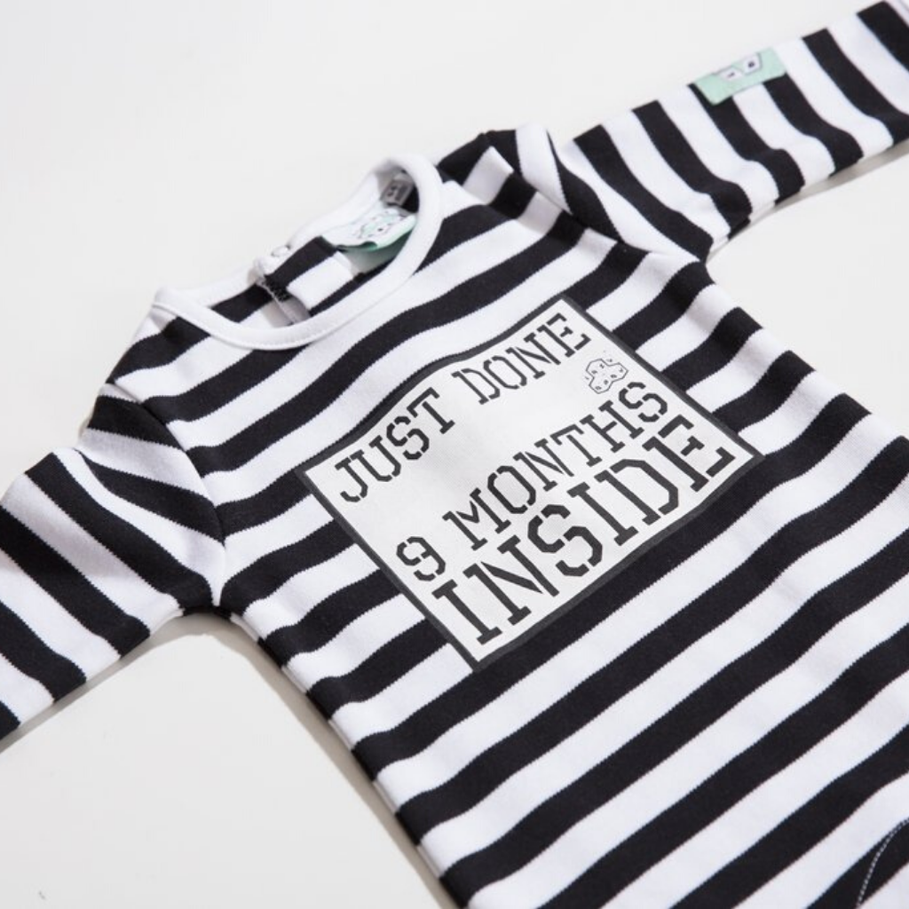 Close up of Just Done 9 Months Inside Baby Grow Black and White 