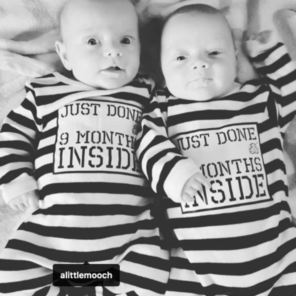 Twins both wearing Just Done 9 Months Inside stripy baby grows